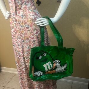 Oh yes it is… It is the green M&M plastic shoulder bag. Great for pool or beach